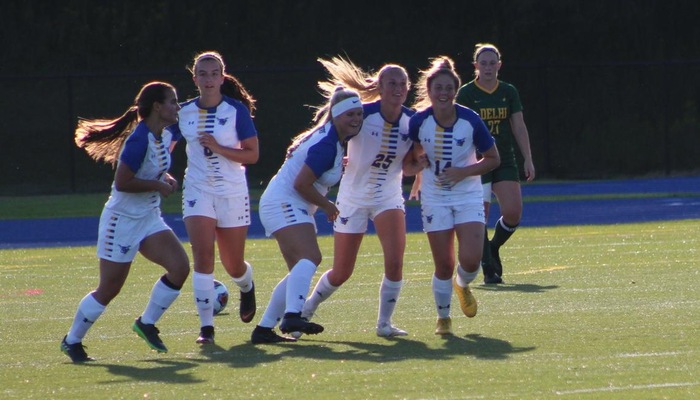 Maggie Meyer and her teammates celebrate the teams first goal of the season.